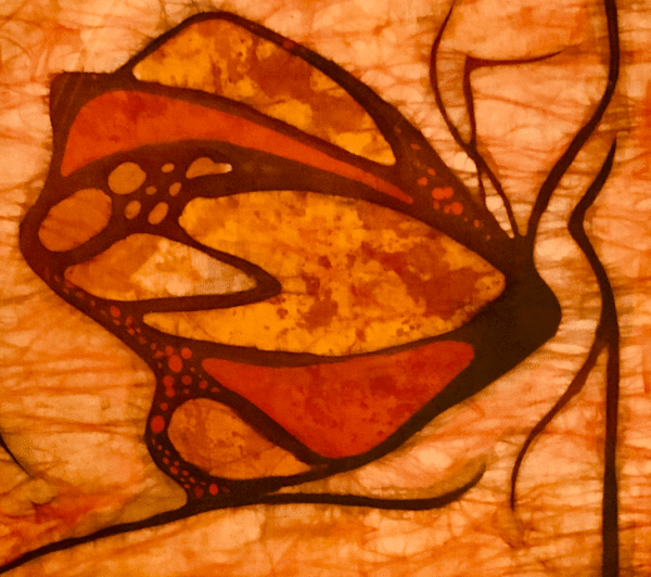 Na zdjęciu widać obraz wykonany w technice batiku. Obraz przedstawia motyla w charakterze secesyjnych ilustracji, w ciepłych intensywnych kolorach: pomarańcz i czerwień. Autorką pracy jest Małgorzata Goczewska, artystka pochodząca z Warszawy, działająca obecnie w Poznaniu.